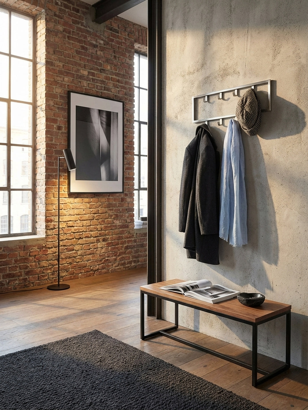 Draufsicht auf einen eleganten Eingangsbereich mit einer 50 cm breiten Hakenleiste aus Metall an der Wand, darunter ein Holzbalken und ein dunkler Bouclé-Läufer auf Eichenparkett._