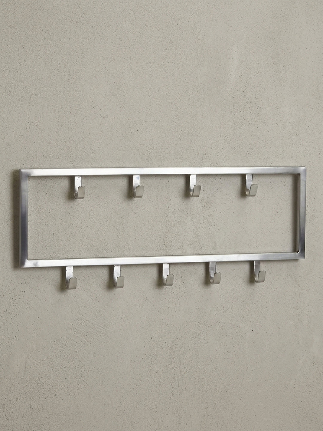 Freigestellte Frontansicht der Design-Wandgarderobe aus Stahl in Silber, 50x20 cm groß, mit ihrer klaren rechteckigen Form und den neun versetzten Kleiderhaken._