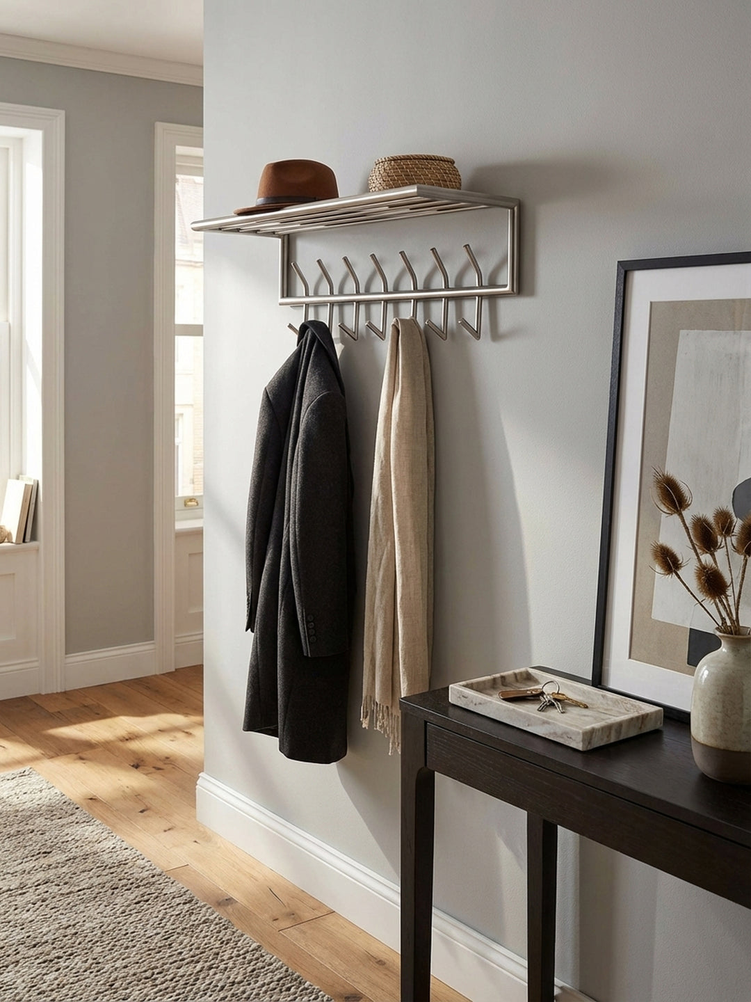 Nahaufnahme der matt polierten Stahl-Oberfläche der Garderobenleiste, die feine Textur und die hochwertige Verarbeitung des robusten Materials betonend._