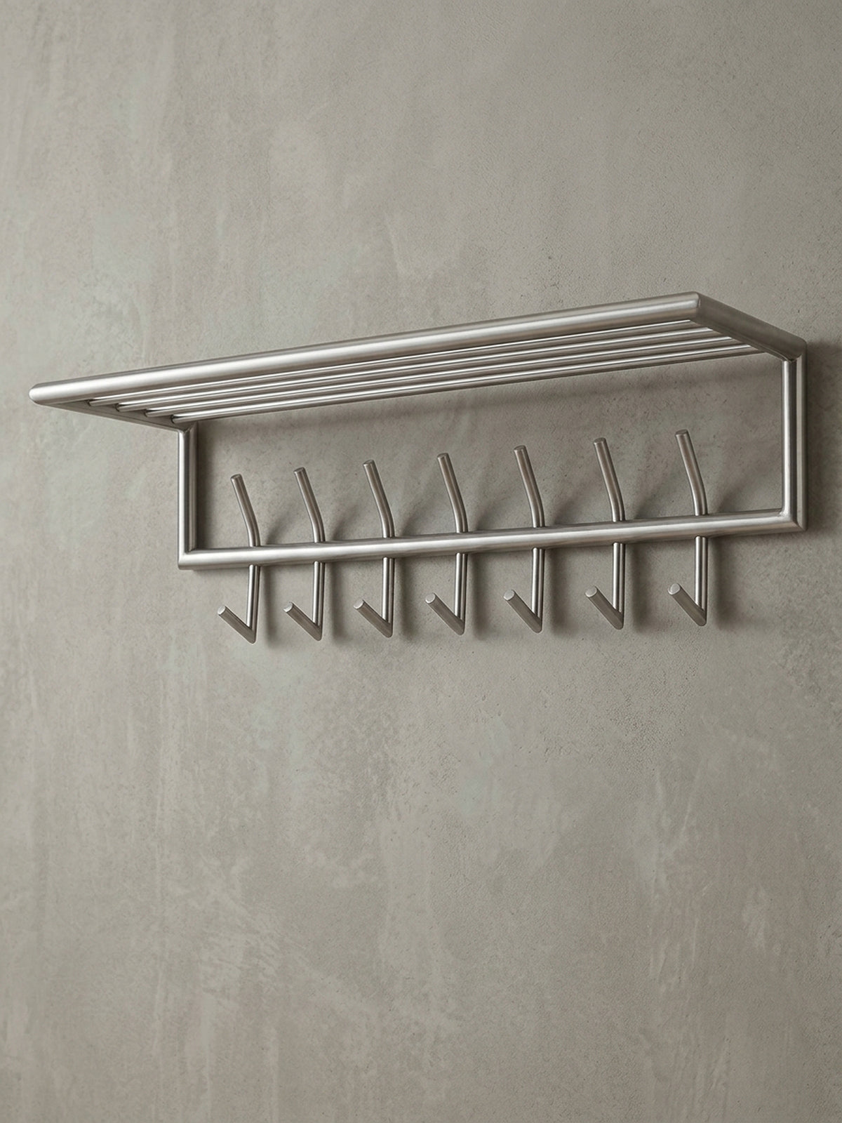 Silberne Design Hakenleiste in 74,5 cm Breite aus der 3/4-Perspektive, die Tiefe der Hutablage von 30 cm und die Anordnung der stabilen Doppelhaken zeigend._