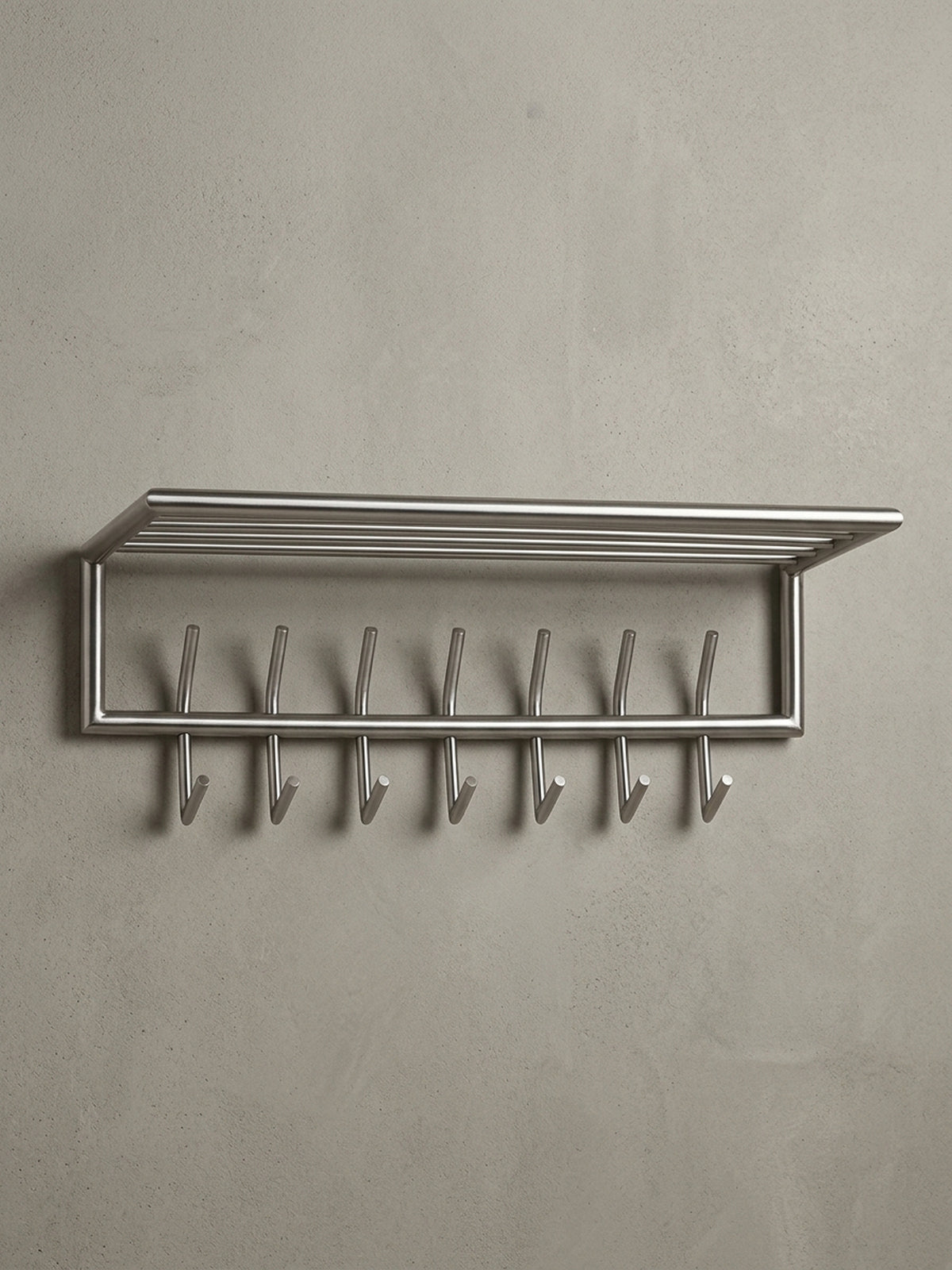 Frontansicht der silbernen Wandgarderobe aus Metall auf weißem Hintergrund, die klare Linienführung und das funktionale Design mit 14 Haken und Ablage hervorhebend._