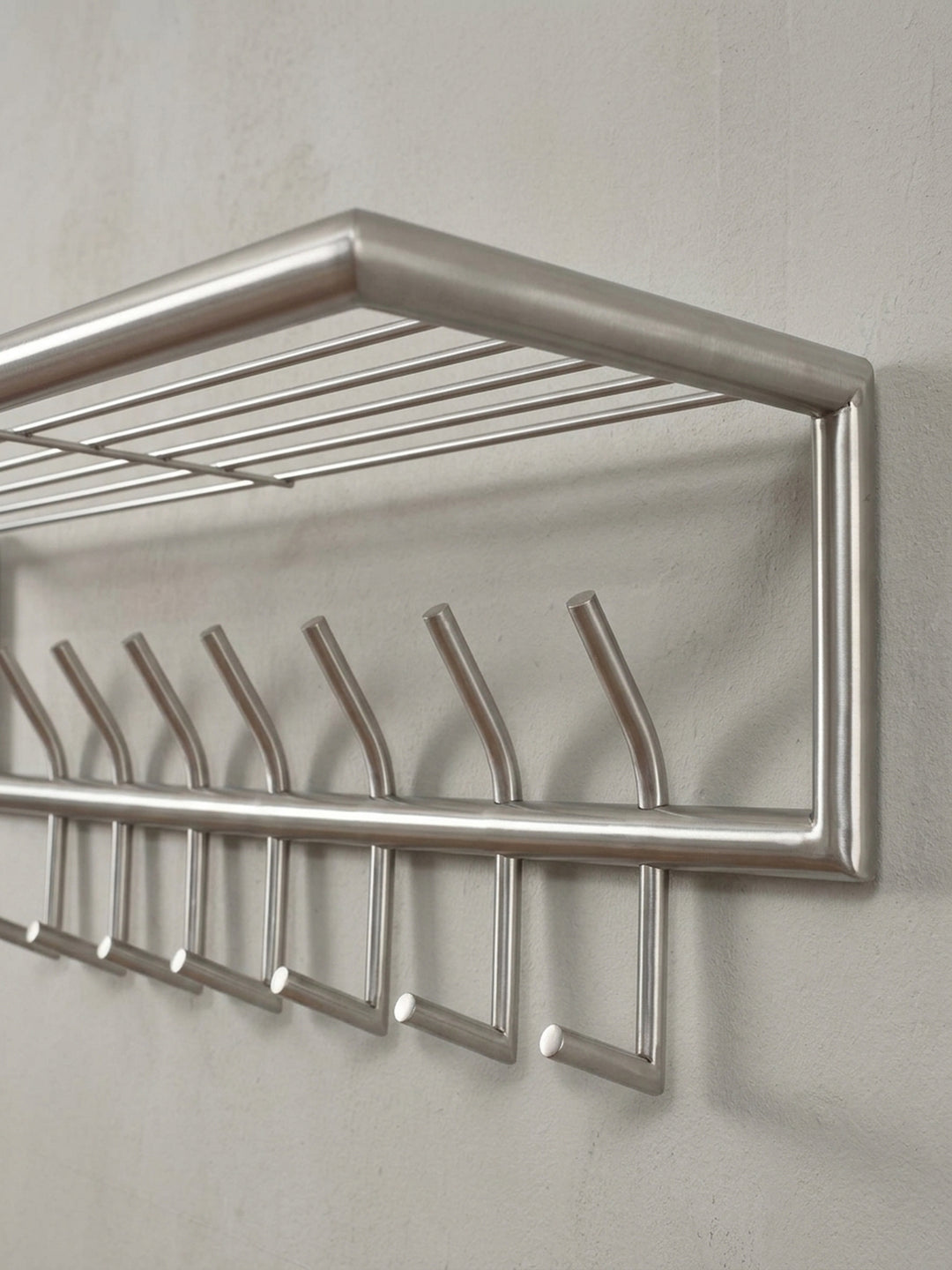 Funktionale Wandgarderobe mit Hutablage aus Stahl, eine alternative Perspektive, die die vielseitige Nutzung im Eingangsbereich für Mäntel und Accessoires zeigt._