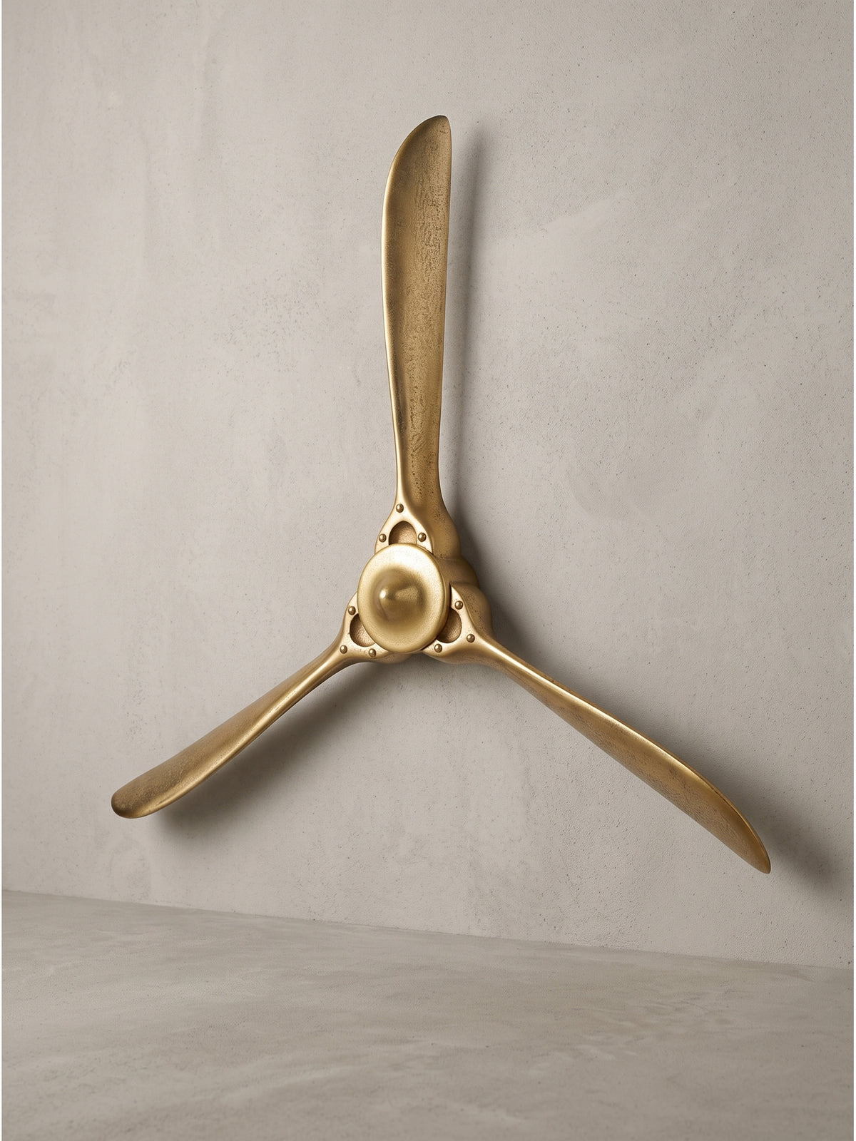 Deko Propeller aus gold lackiertem Aluminium mit drei Flügeln 85x85 cm in Frontalansicht vor weißem Hintergrund._