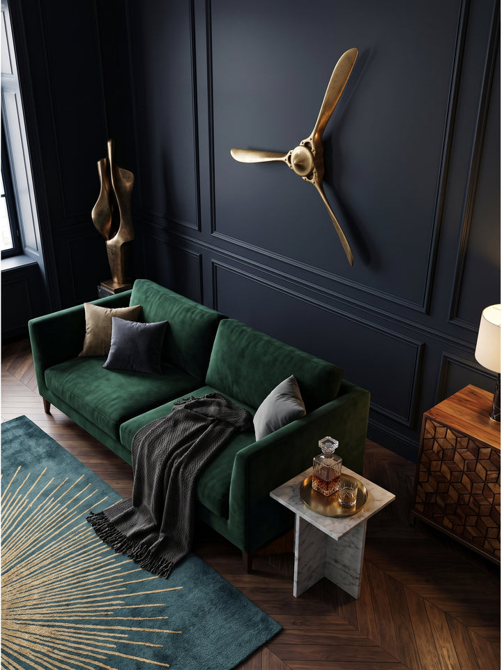 Blick von oben auf den goldenen Wandpropeller 85x85 cm aus Metall über einem dunklen Walnussboden im luxuriösen Wohnzimmer._