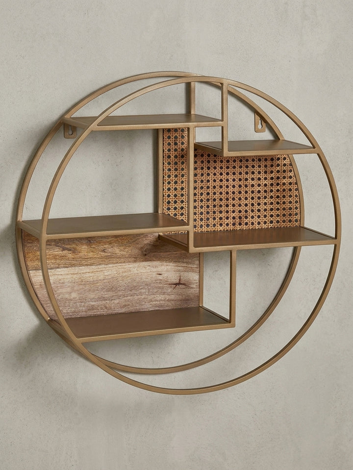 Gesamtüberblick des runden Wandregals im Industrial-Stil, das durch den Materialmix aus Mangoholz, Rattan und Messing einen warmen und organischen Charakter erhält._