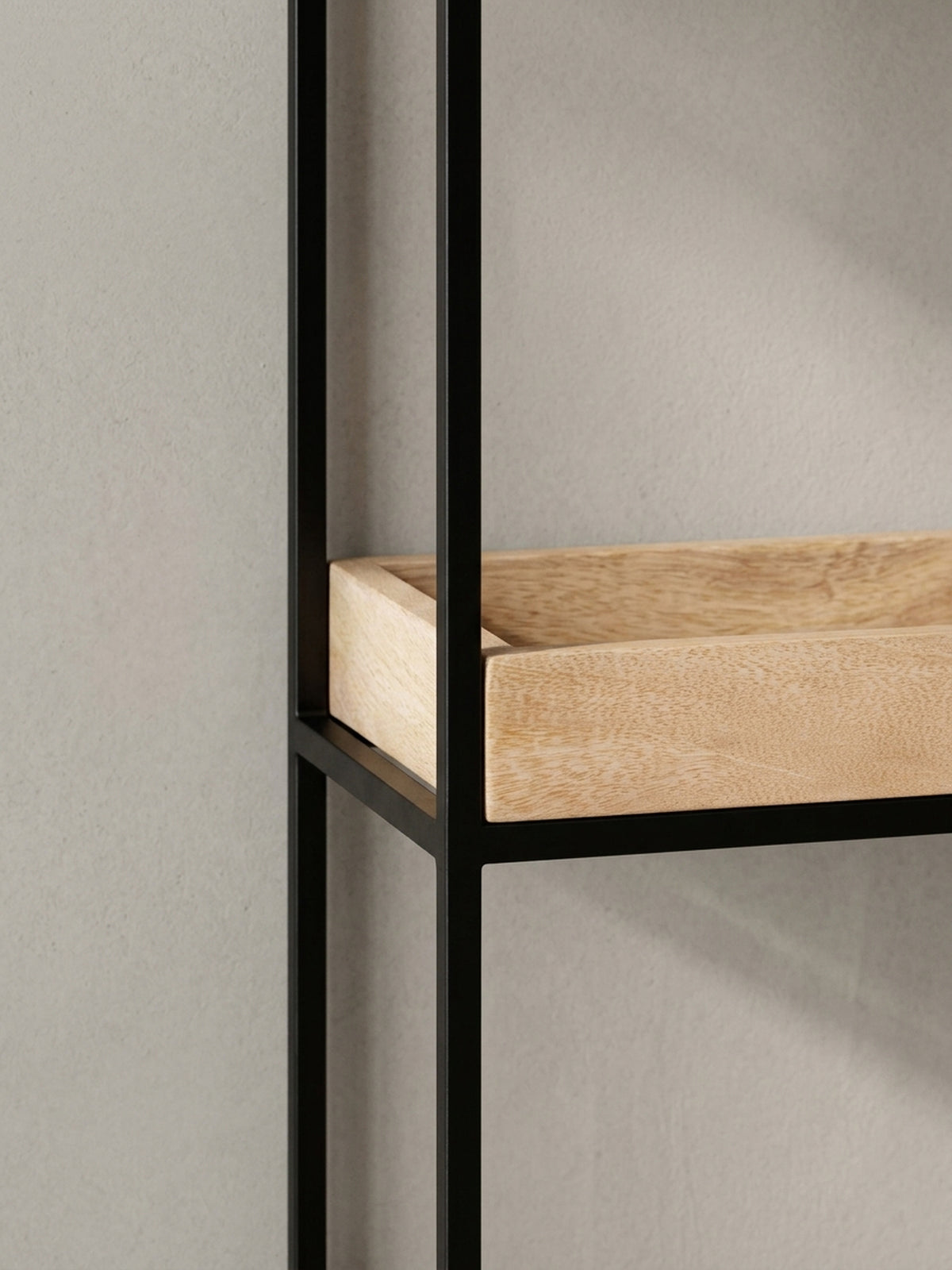 Alternatives Design-Wandregal aus einer anderen Perspektive, das den Kontrast zwischen dem warmen Mangoholz und dem kühlen, schwarzen Metallrahmen unterstreicht.