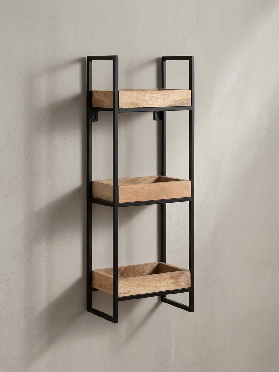 Schrägansicht des Hängeregals aus Metall und Mango Massivholz, die die Tiefe der praktischen Tablett-Ablagen und die schlanke Silhouette betont._