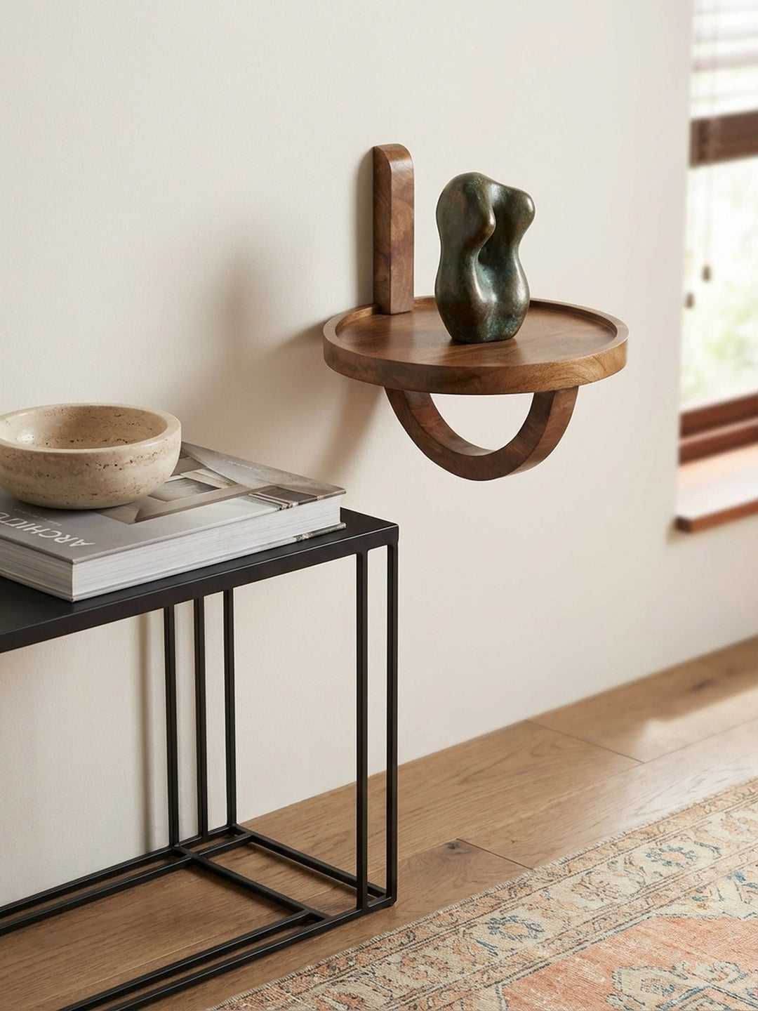 Ein rundes Akzentregal aus Holz, dekoriert mit einer kleinen Sukkulente im Betontopf, schafft eine wohnliche Atmosphäre im Wohnzimmer._