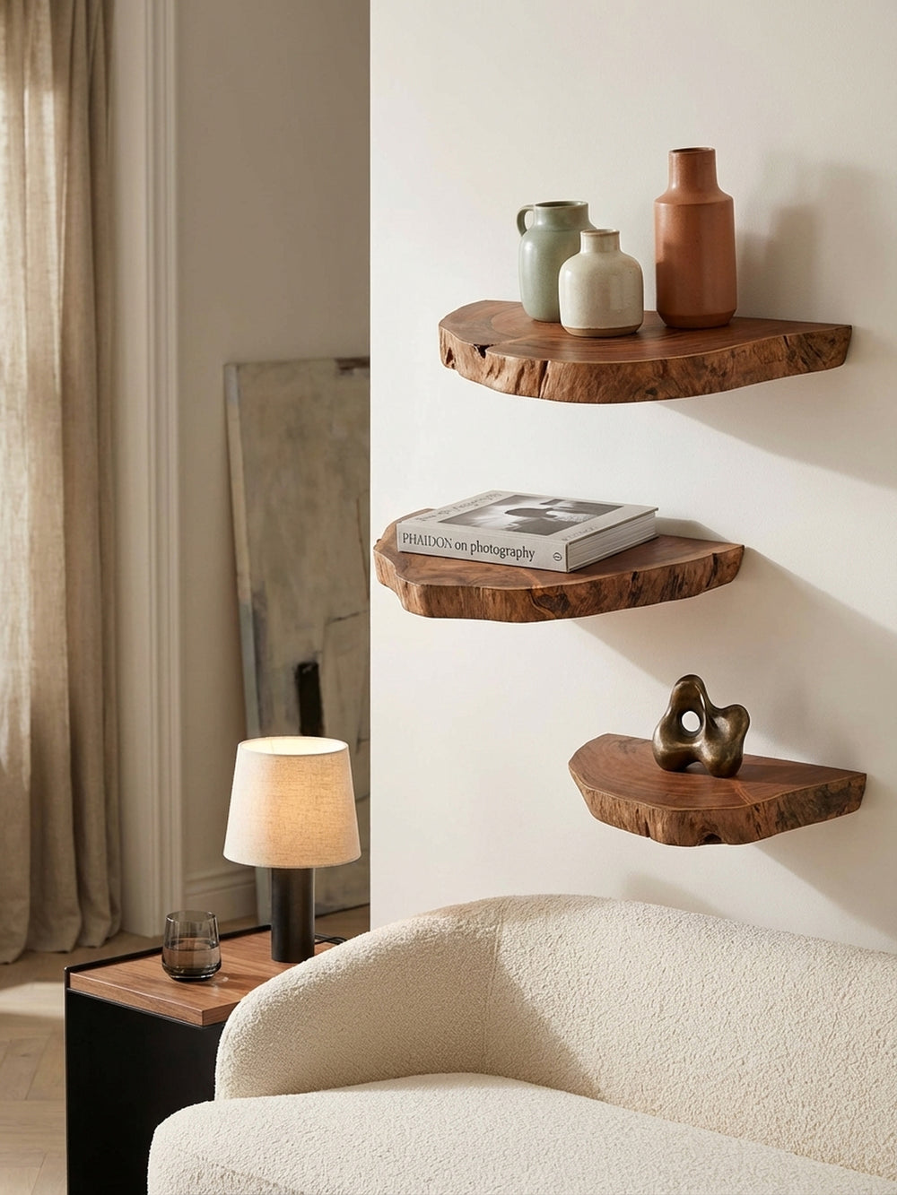 Detailansicht eines Akazie-Wandboards mit einem Stapel Architekturbücher, das als schwebendes Nachttisch-Regal im Schlafzimmer genutzt wird._