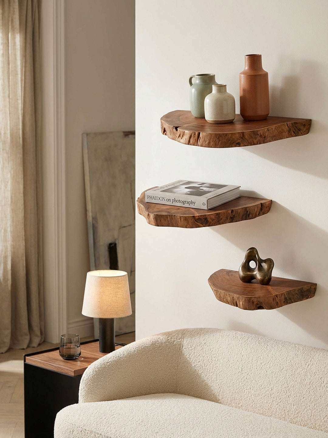 Detailansicht eines Akazie-Wandboards mit einem Stapel Architekturbücher, das als schwebendes Nachttisch-Regal im Schlafzimmer genutzt wird._