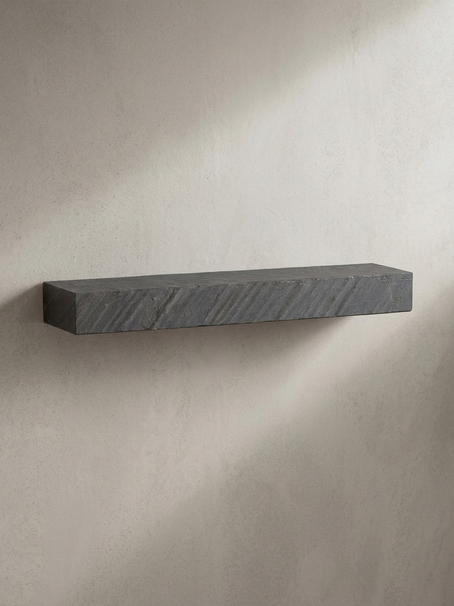 Das massive Hängeregal aus Mangoholz in einer schrägen 3/4-Ansicht, die die Tiefe von 20 cm und die gebrochenen Kanten der Steinoptik hervorhebt._