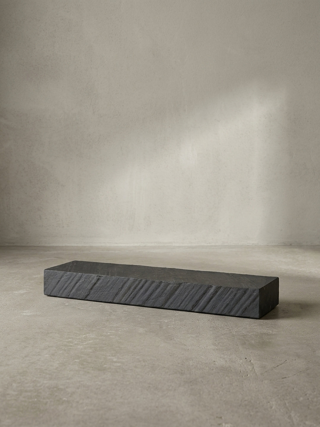 Freigestellte Frontalansicht des 90 cm langen Schweberegals in Anthrazit mit seiner markanten, strukturierten Oberfläche in moderner Steinoptik._