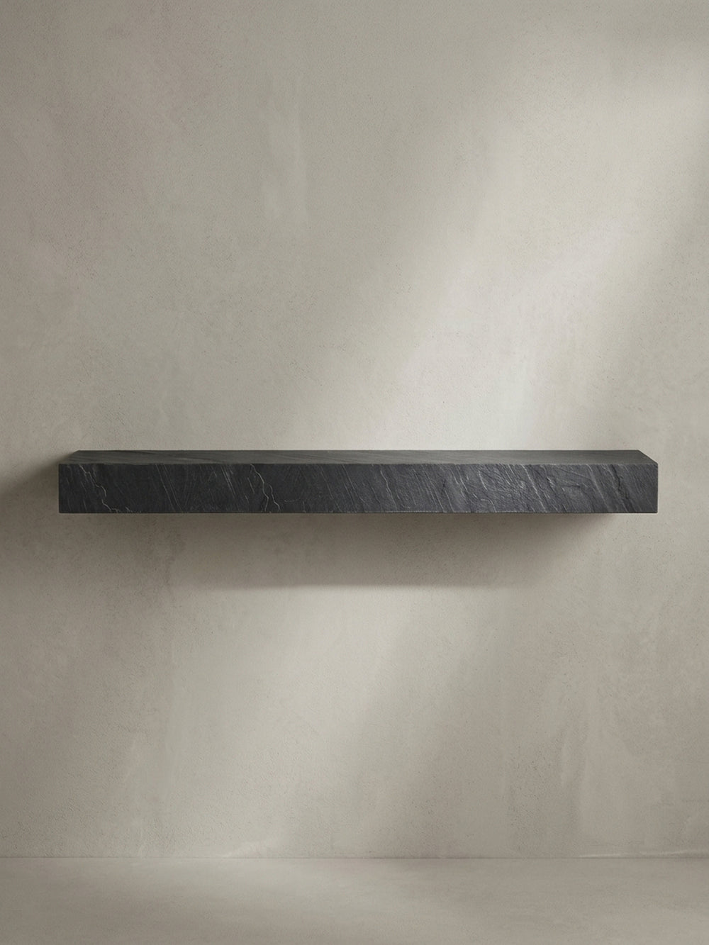 Seitenansicht des 10 cm hohen Hängeregals, das die massive und blockartige Silhouette des Designs in Steinoptik im Profil betont._