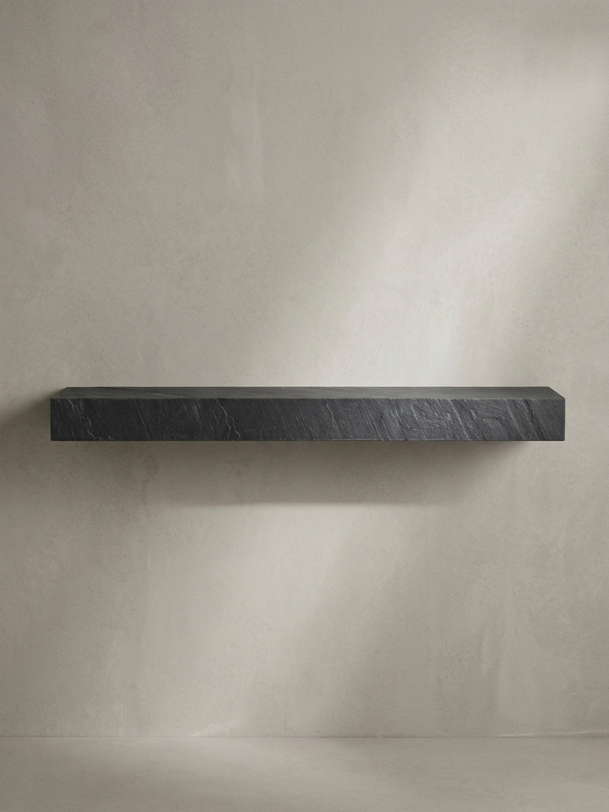 Seitenansicht des 10 cm hohen Hängeregals, das die massive und blockartige Silhouette des Designs in Steinoptik im Profil betont._