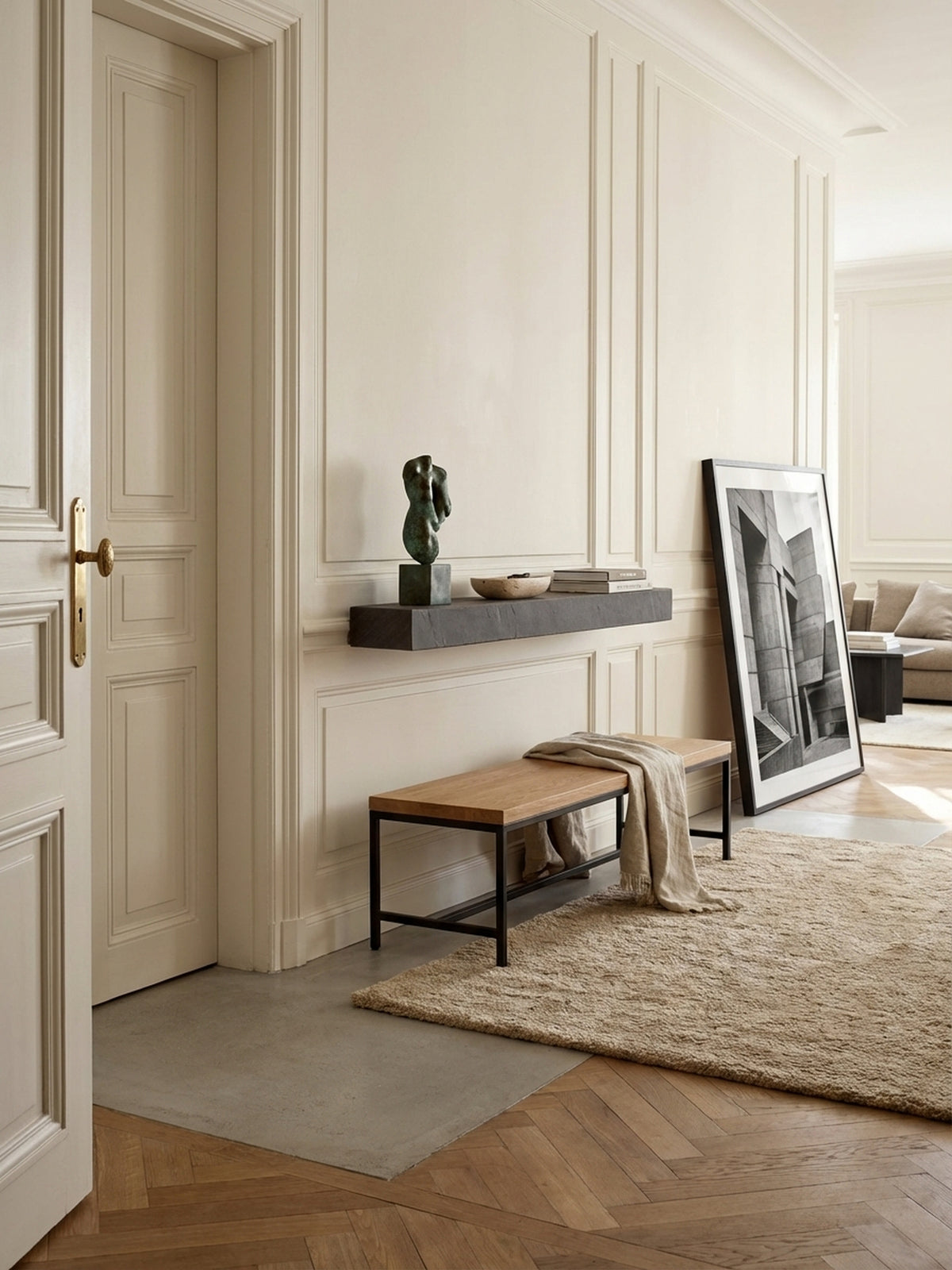 Modernes Wandregal in anthrazitfarbener Steinoptik, montiert über einer Eichenholzbank in einem minimalistisch gestalteten Flur mit poliertem Betonboden._