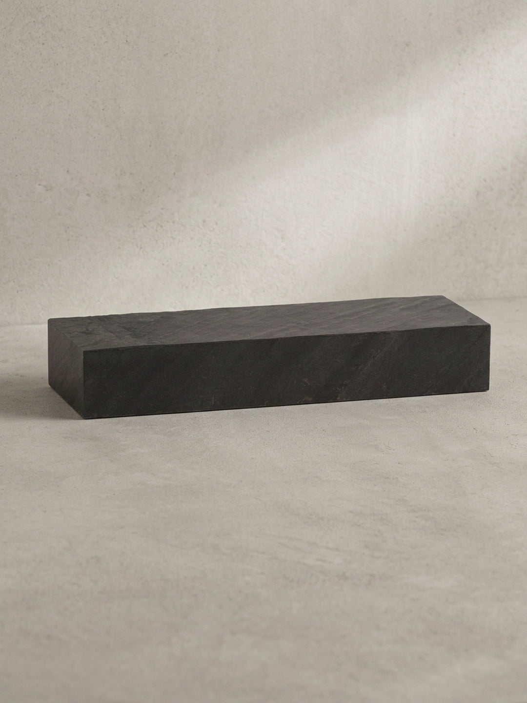 Freigestellte Frontansicht des 60x10x20 cm großen Wandregals aus massivem Mangoholz mit einer modernen Oberfläche in Steinoptik._