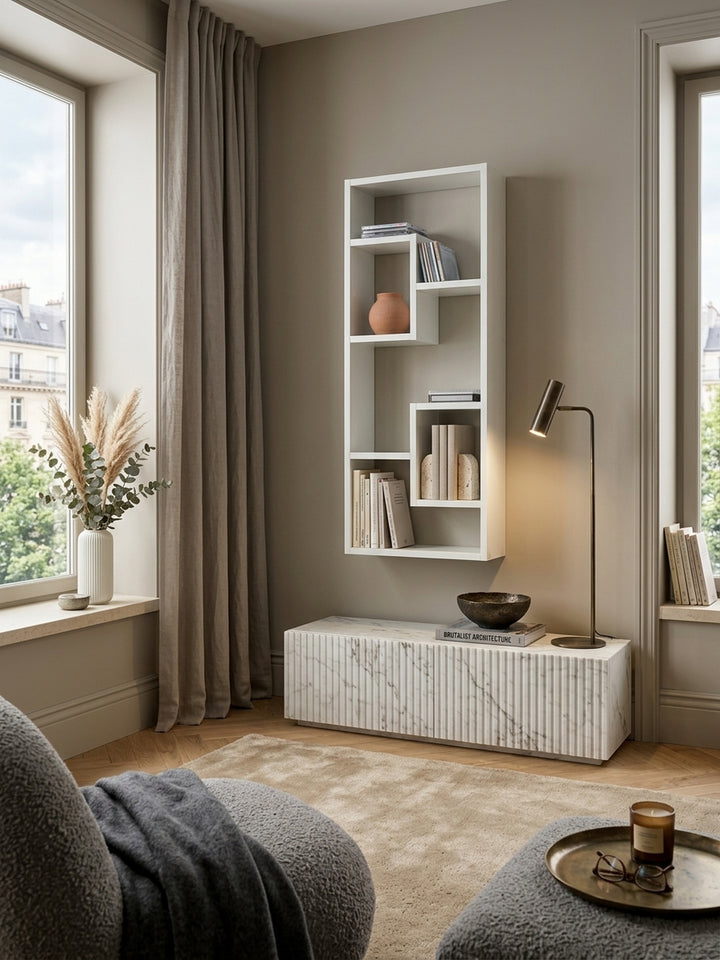 Modernes weißes Wandregal 36x90x15cm freischwebend montiert in eleganter Leseecke. Das asymmetrische Holzregal bietet stilvollen Stauraum über einer gemütlichen Lounge-Situation._