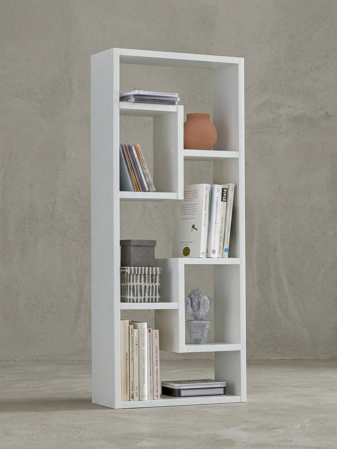 Schmales Wandregal in Weiß auf neutralem Grund. Die asymmetrischen Ablagefächer des 90cm hohen Holzregals erzeugen ein modernes Design für stilvolle Wanddekoration im Wohnbereich._