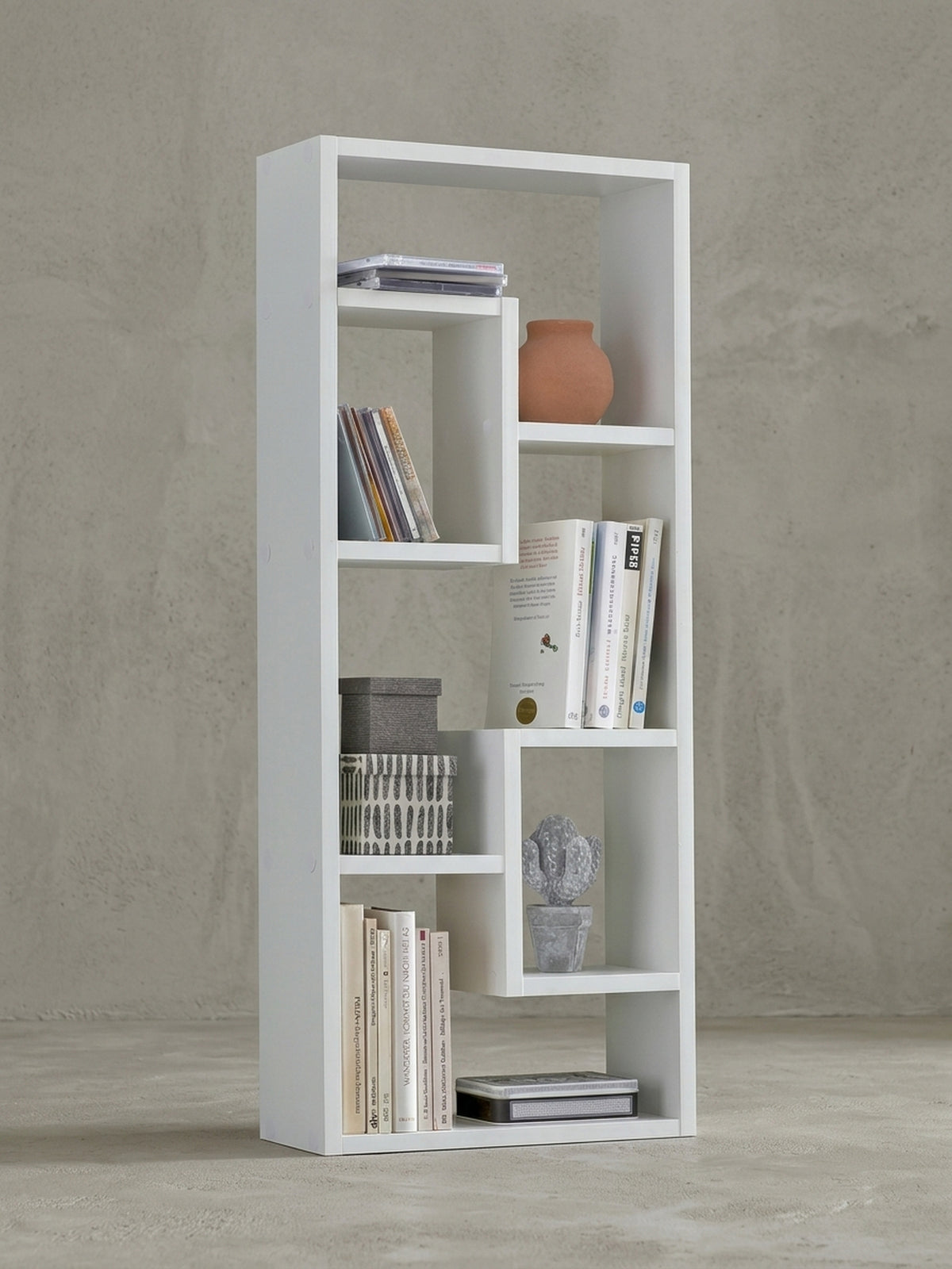 Schmales Wandregal in Weiß auf neutralem Grund. Die asymmetrischen Ablagefächer des 90cm hohen Holzregals erzeugen ein modernes Design für stilvolle Wanddekoration im Wohnbereich._