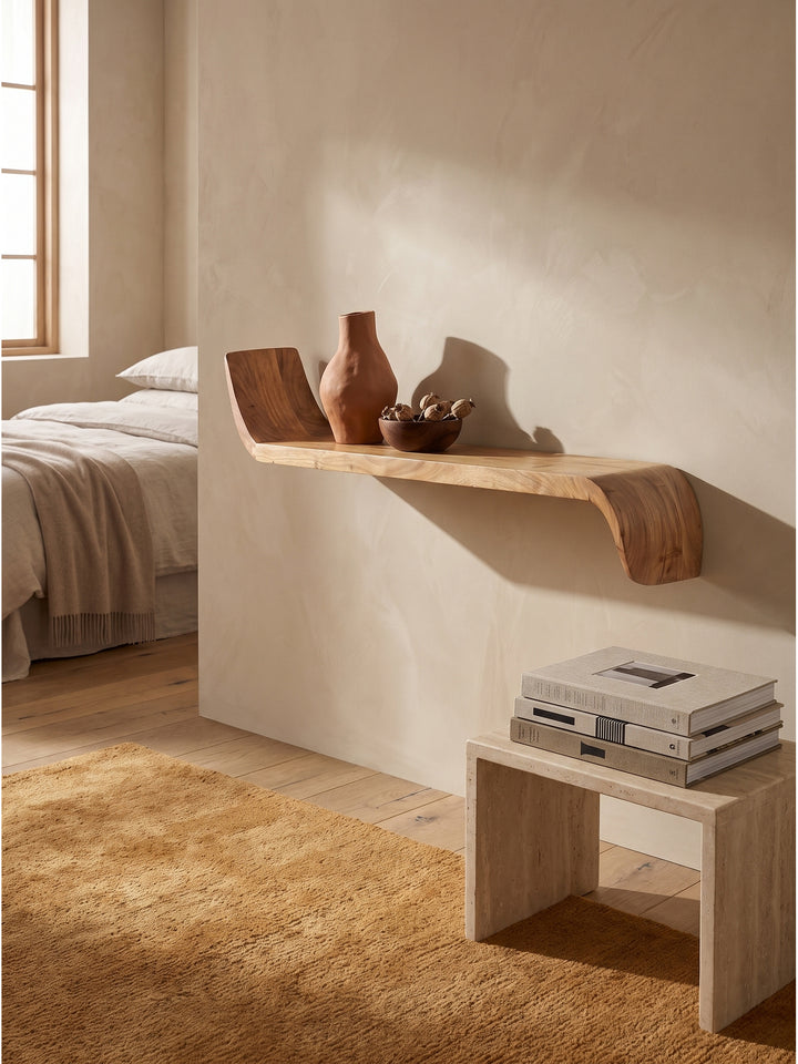 Schwebendes Wandregal aus Mango Massivholz mit geschwungenen Enden im organisch modernen Wohnzimmer an beigefarbener Kalkputz-Wand_