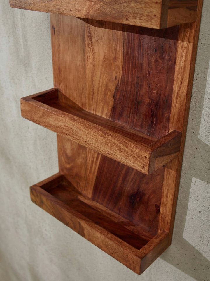 Nahaufnahme eines Fachs des Wandregals aus Sheesham, die saubere Verarbeitung der Kanten und die schützende Lackierung der Holzoberfläche zeigend._