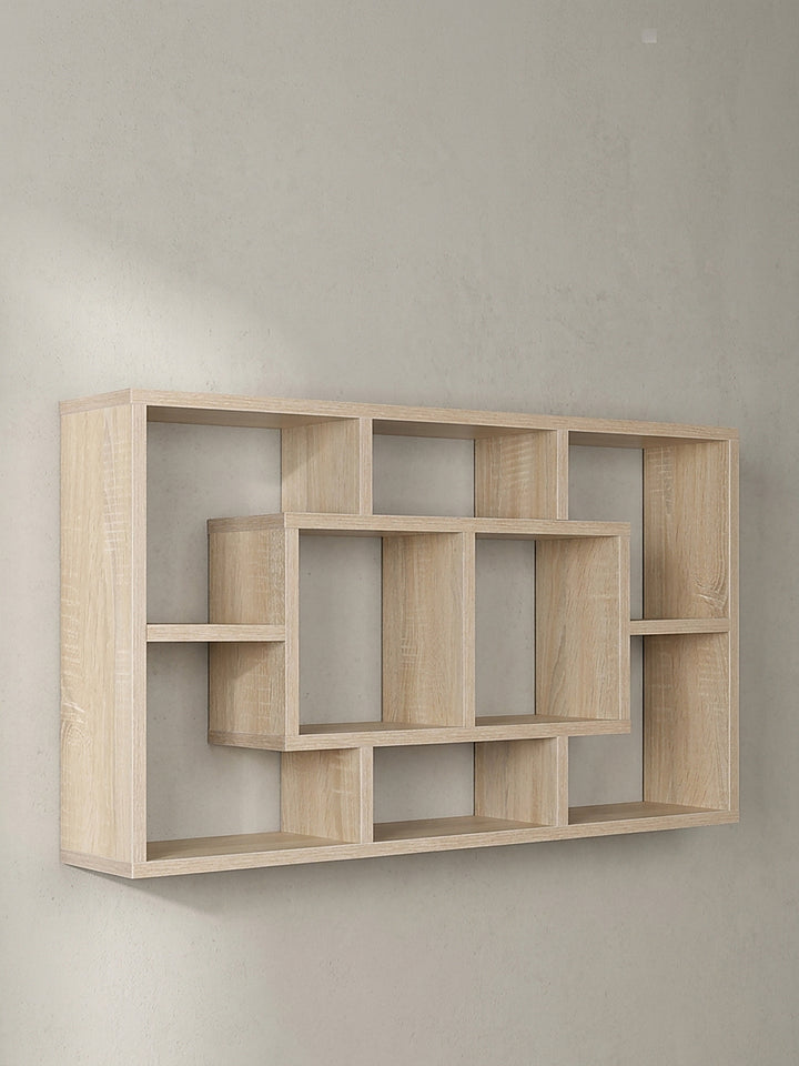 Frontalansicht des leeren Wandregals 85x47x16 cm mit ineinandergreifenden offenen Fächern in heller Holzoptik vor einem neutralen Hintergrund_