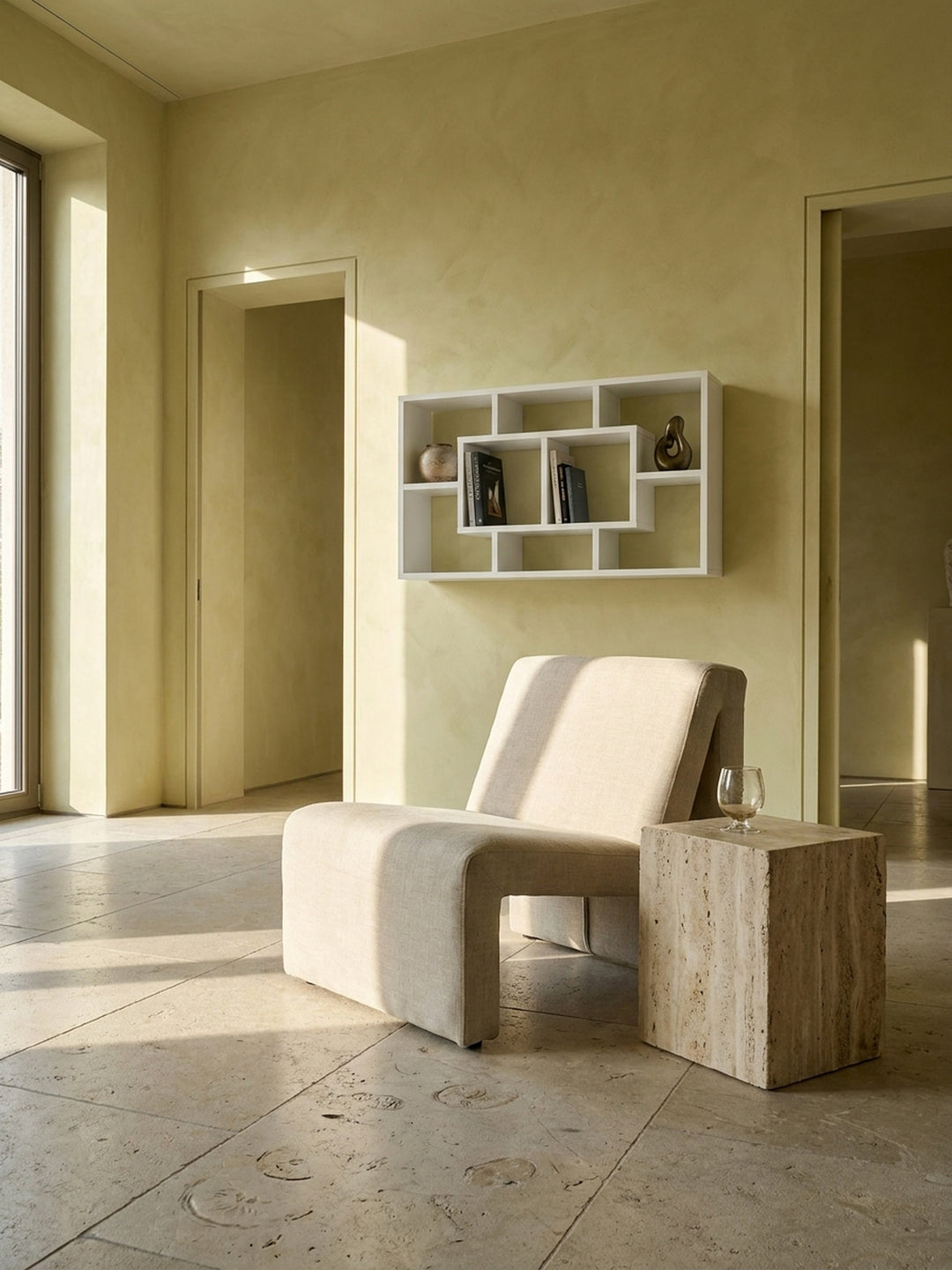 Geometrisches Wandregal aus weißem MDF im minimalistischen Wohnzimmer an einer handverputzten Wand über einem Leinen-Sessel_