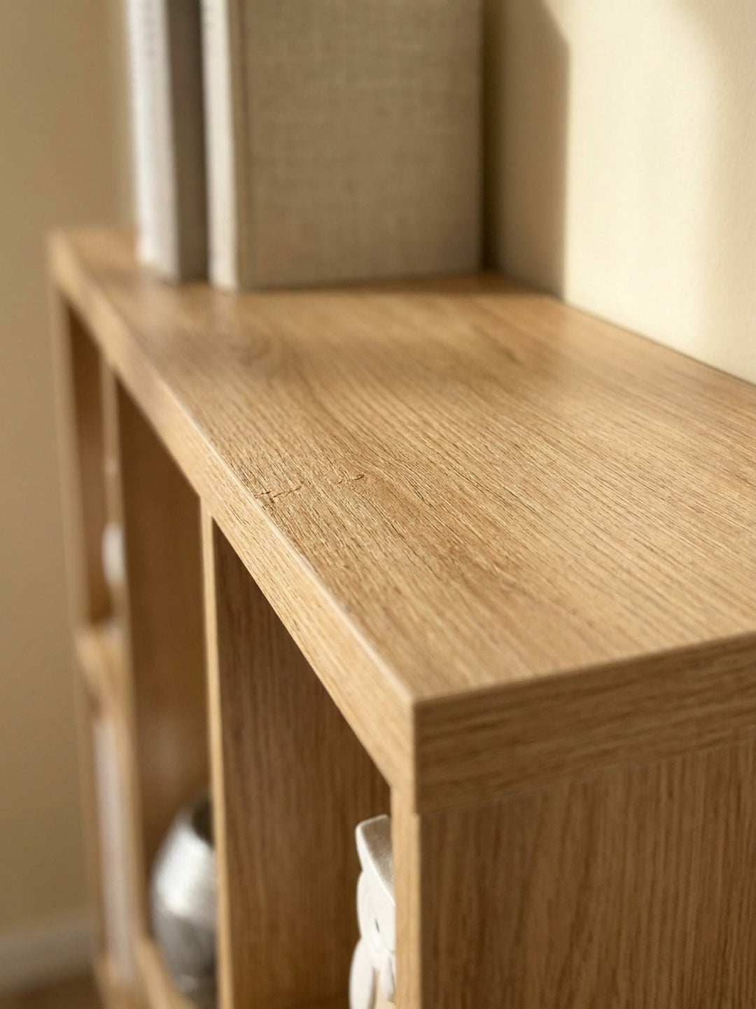 Nahaufnahme der warmen Buchenholz-Maserung und der nahtlosen Kantenverarbeitung des Wandboards im skandinavisch inspirierten Arbeitszimmer._
