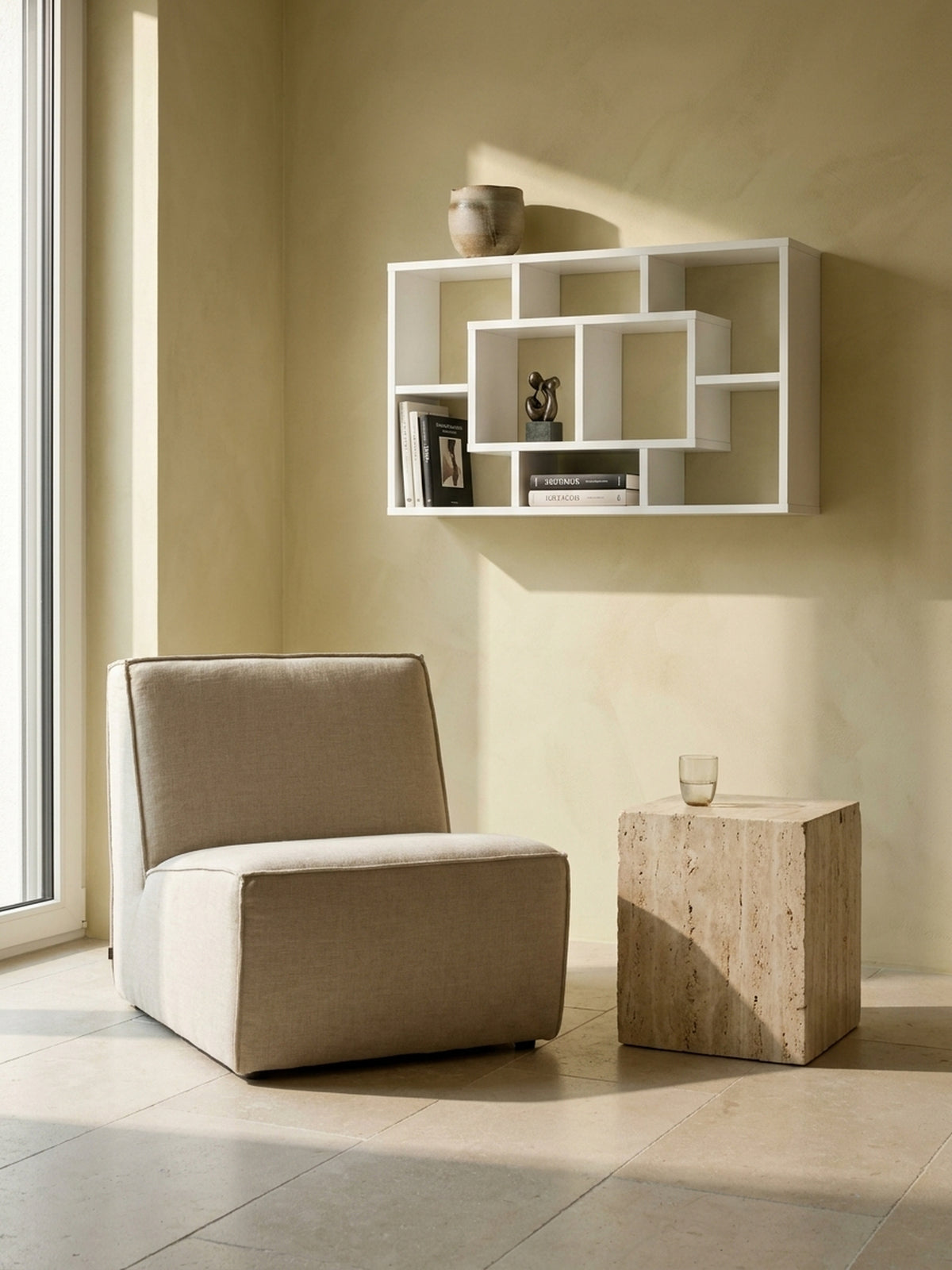 Weißes Design-Regal an der Wand montiert, harmonisch kombiniert mit einem Travertin-Block und puristischem Kalksteinboden_