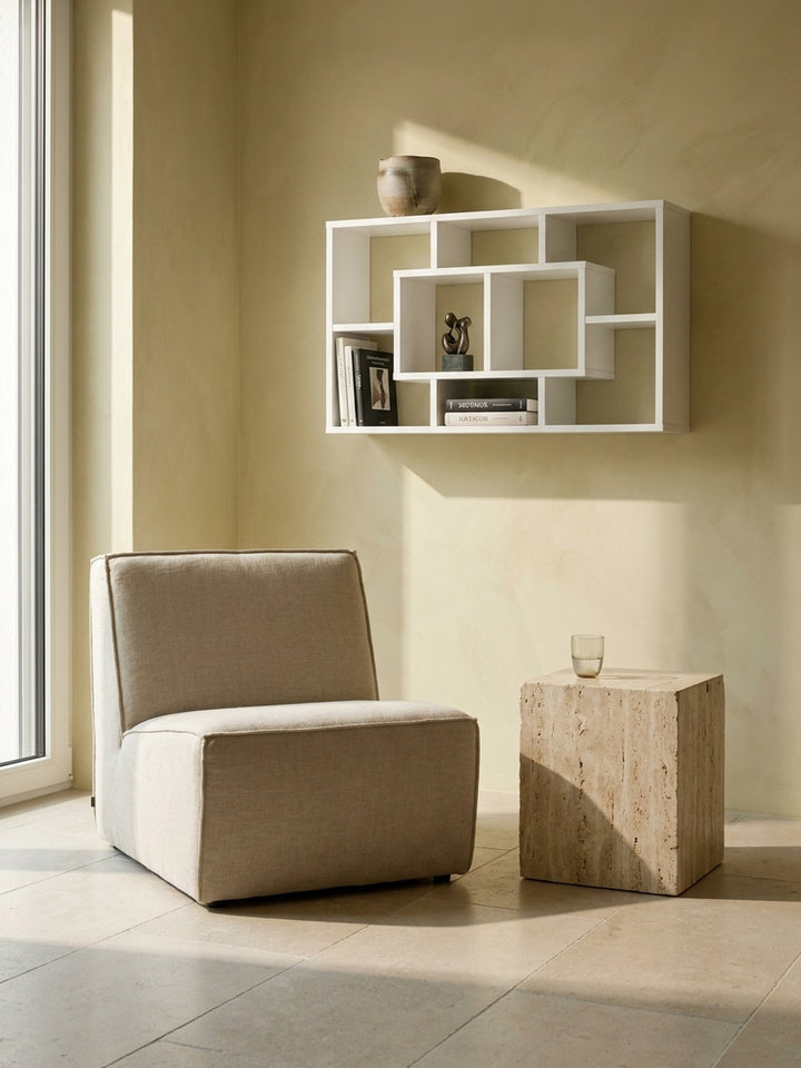 Weißes Design-Regal an der Wand montiert, harmonisch kombiniert mit einem Travertin-Block und puristischem Kalksteinboden_