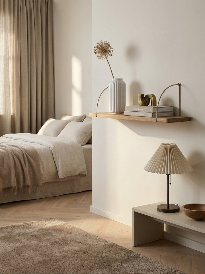Elegantes Wandregal aus Mango Massivholz mit goldenen Halterungen, stilvoll dekoriert mit Büchern und einer Vase in einem modernen Wohnzimmer._
