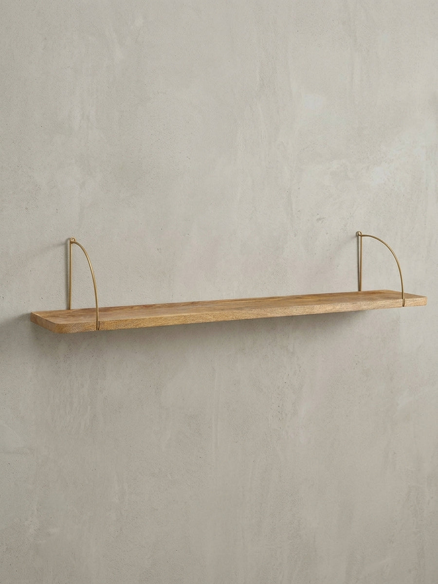 Gesamtansicht des großen Wandregals für das Wohnzimmer, das die geradlinige Form des Mangoholzes im Kontrast zu den organischen Metallbügeln zeigt._