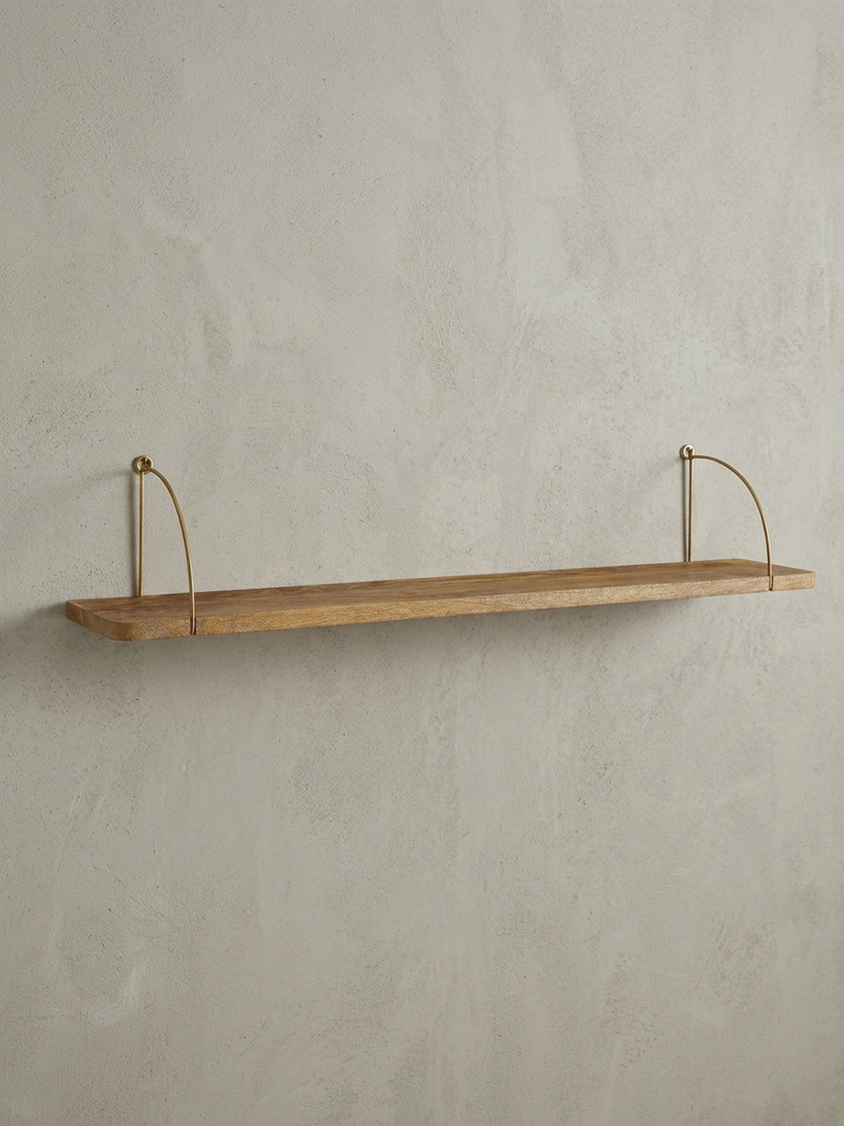 Frontansicht des 100 cm breiten Wandregals aus Mangoholz mit elegant geschwungenen, goldfarbenen Metallhalterungen auf weißem Hintergrund._