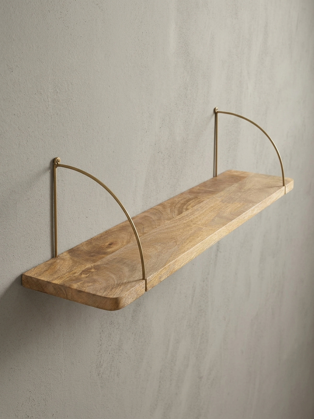 Detailaufnahme einer der goldfarbenen Halterungen des Wandregals, die durch das massive Mangoholz geführt wird und einen Hauch von Industrial-Chic verleiht._