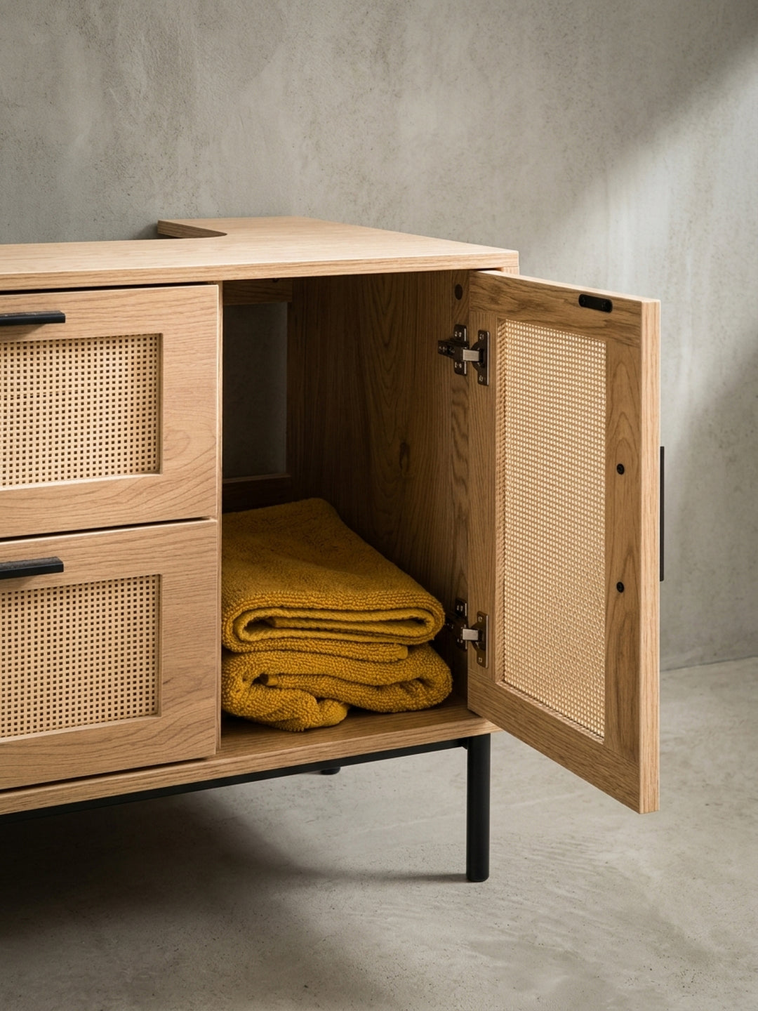 Perspektivische Ansicht des stehenden Waschbeckenschranks, die das Zusammenspiel von glatten Oberflächen und dem Wiener Geflecht betont._