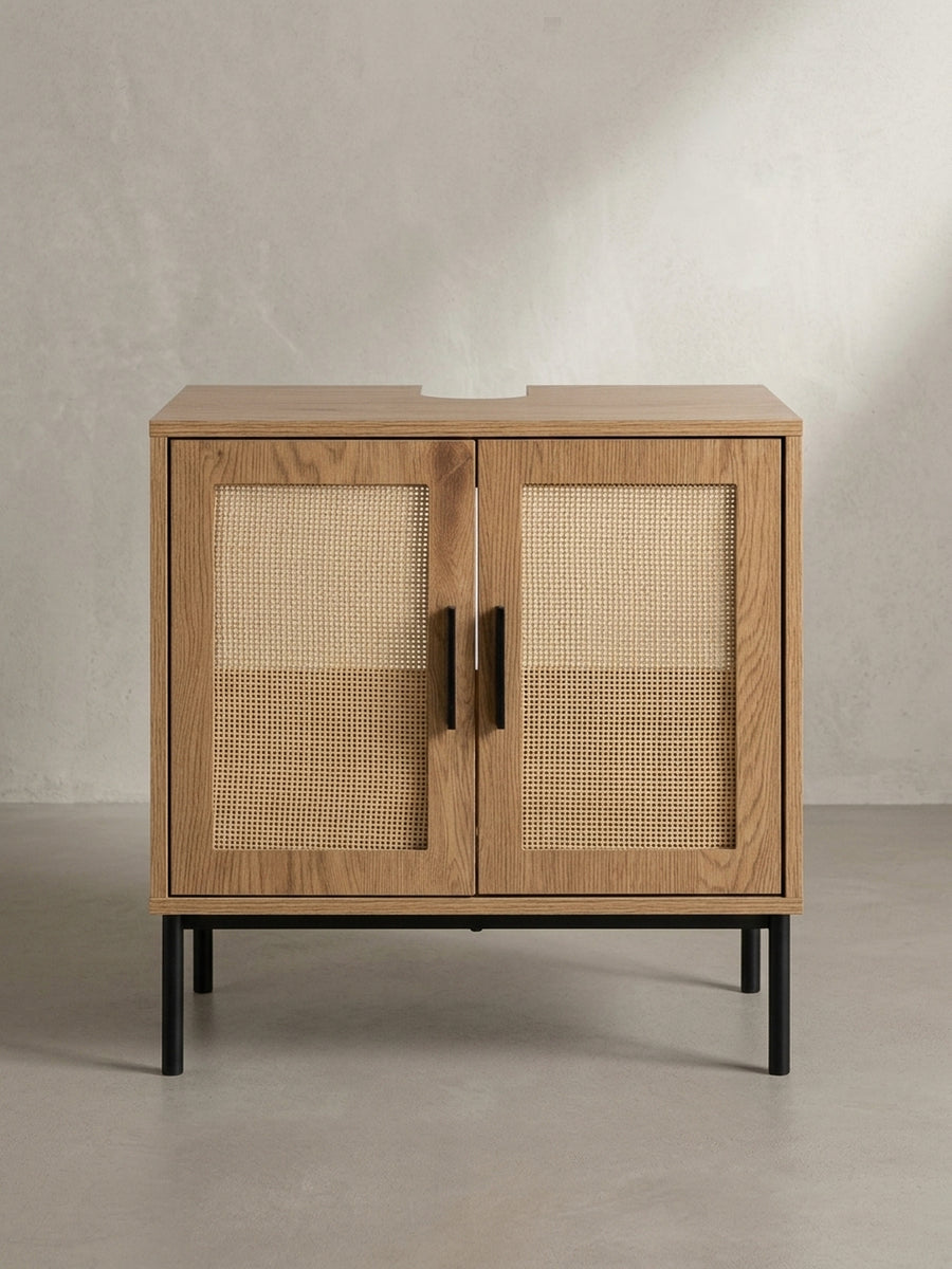 3/4-Ansicht des Badschranks mit Rattangeflecht, der die Tiefe von 40 cm und die harmonische Kombination aus heller Eichenoptik und schwarzen Akzenten zeigt._