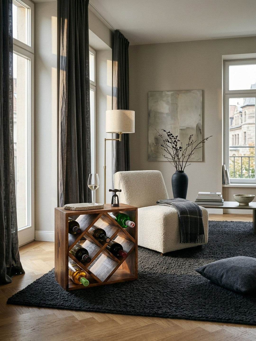 Luxuriöses Weinregal aus massivem Sheesham-Holz im eleganten Wohnzimmer. Das 40x40x25cm große Flaschenregal steht stilvoll neben einem Loungesessel auf dunklem Bouclé-Teppich._