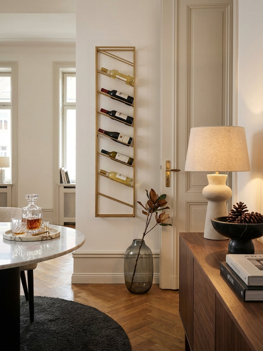 Modernes goldenes Weinregal aus Metall, an einer weißen Wand im Esszimmer montiert und stilvoll mit acht Weinflaschen bestückt._
