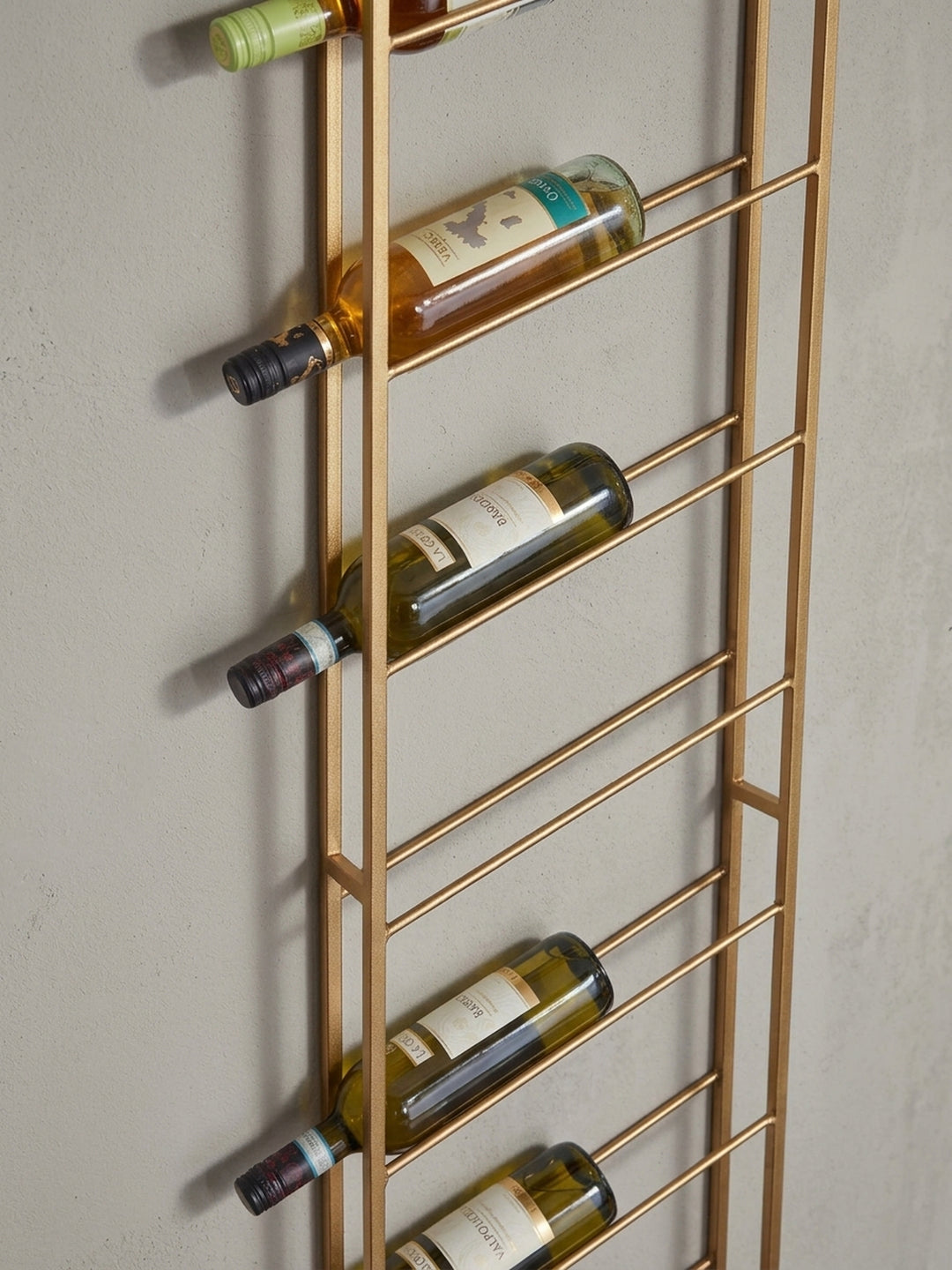 Alternativer Blickwinkel auf das Weinregal aus Eisen, der das Spiel von Licht und Schatten auf der goldenen geometrischen Struktur betont._