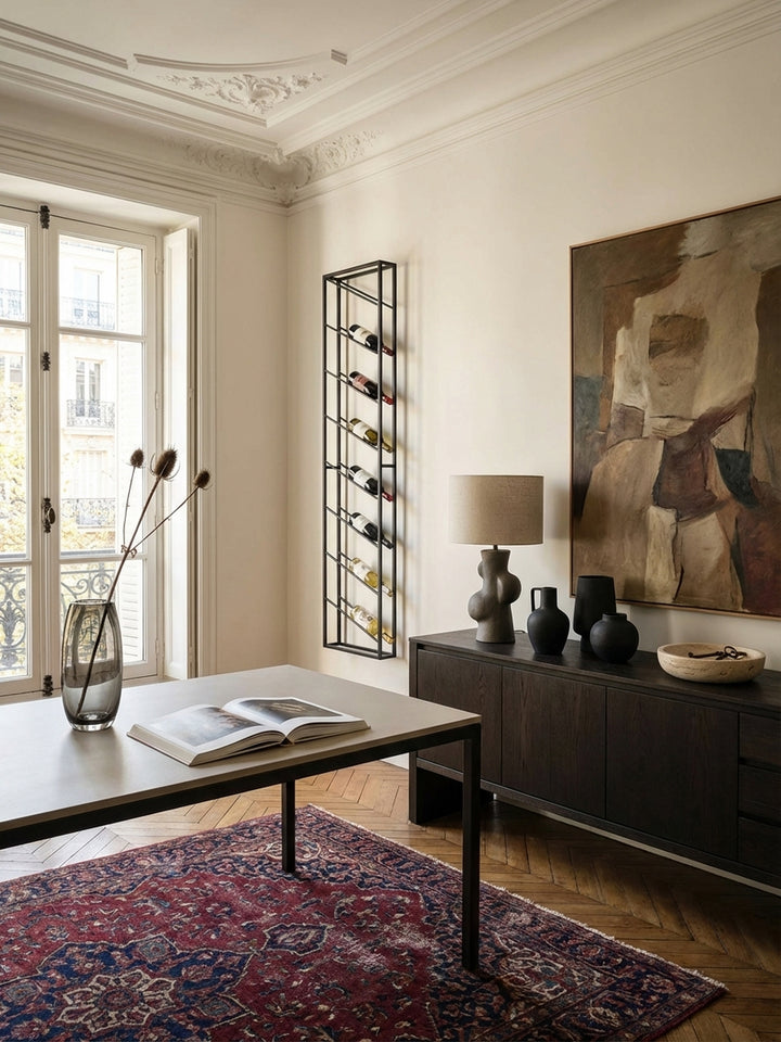 Ein schmales, schwarzes Wand-Weinregal aus Metall, montiert in einem hellen Esszimmer und bestückt mit acht Weinflaschen, schafft einen eleganten Blickfang._