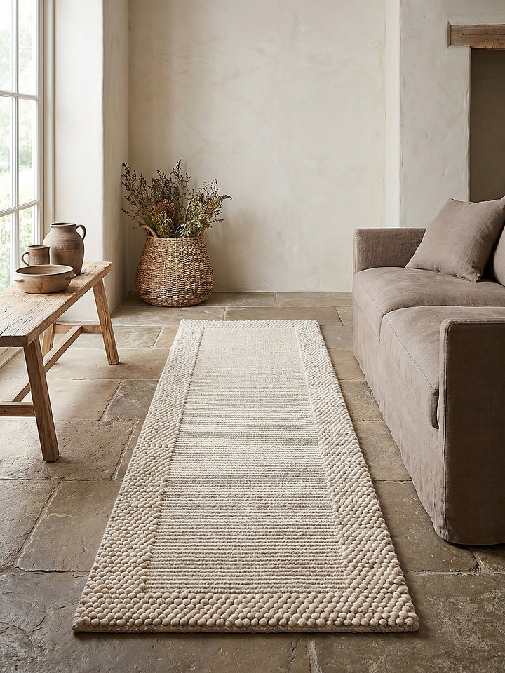Teppich Beige-Natur Läufer Editorial Interior als Designobjekt drapiert hochwertige Wohnaccessoires_