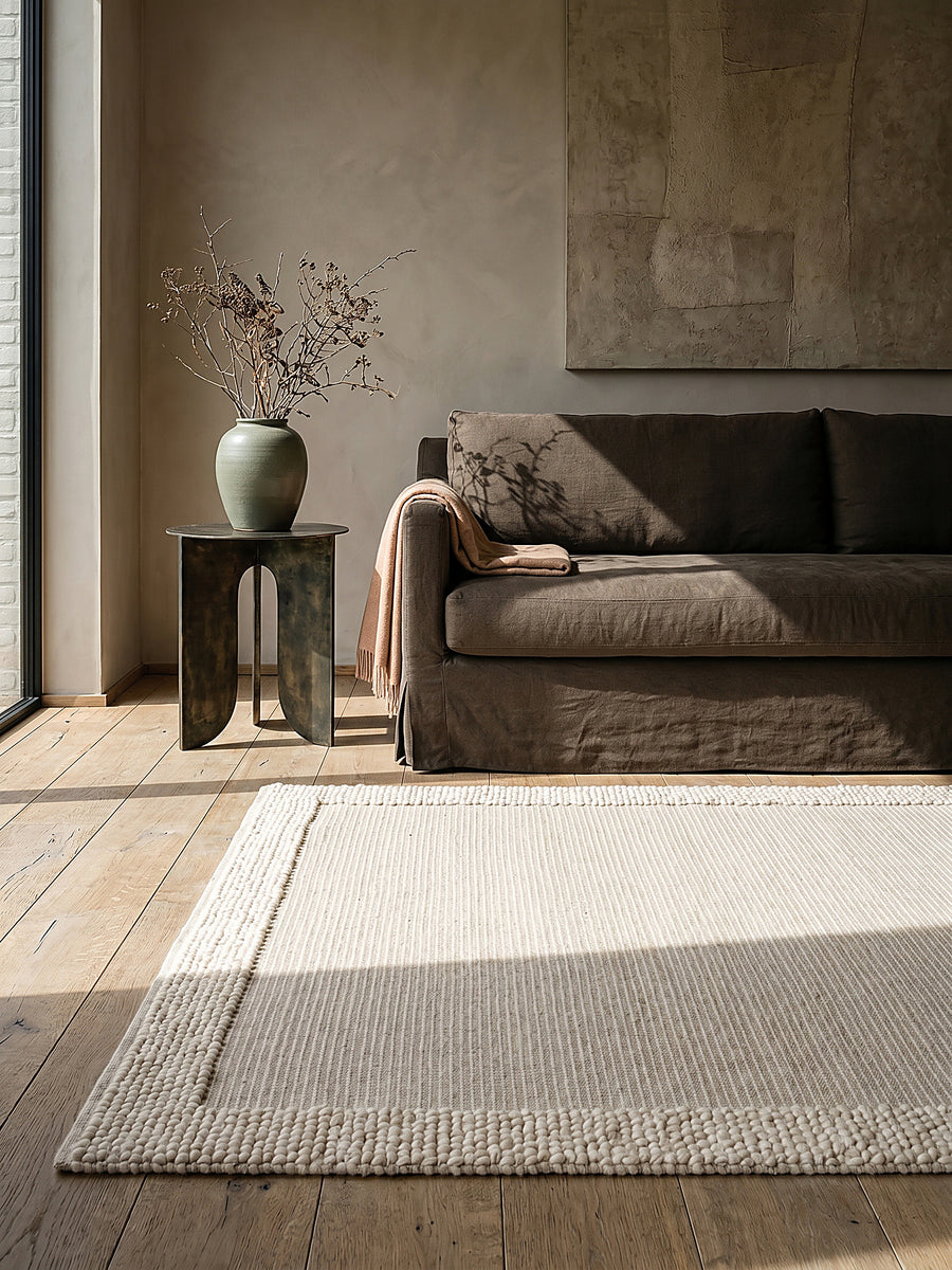 Teppich Beige-Natur rechteckig Editorial Interior als Designobjekt drapiert hochwertige Wohnaccessoires_