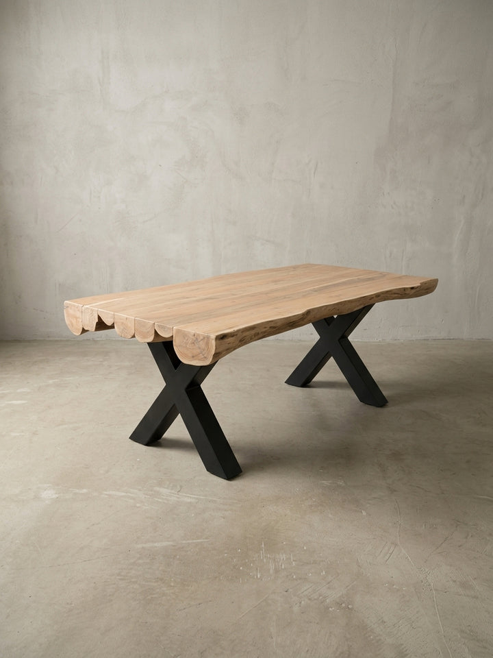 Alternative Perspektive des Baumkanten-Tisches aus Akazienholz. Der Kontrast zwischen warmem Naturholz und industriellem schwarzen Metallgestell prägt das elegante Esszimmer Design._