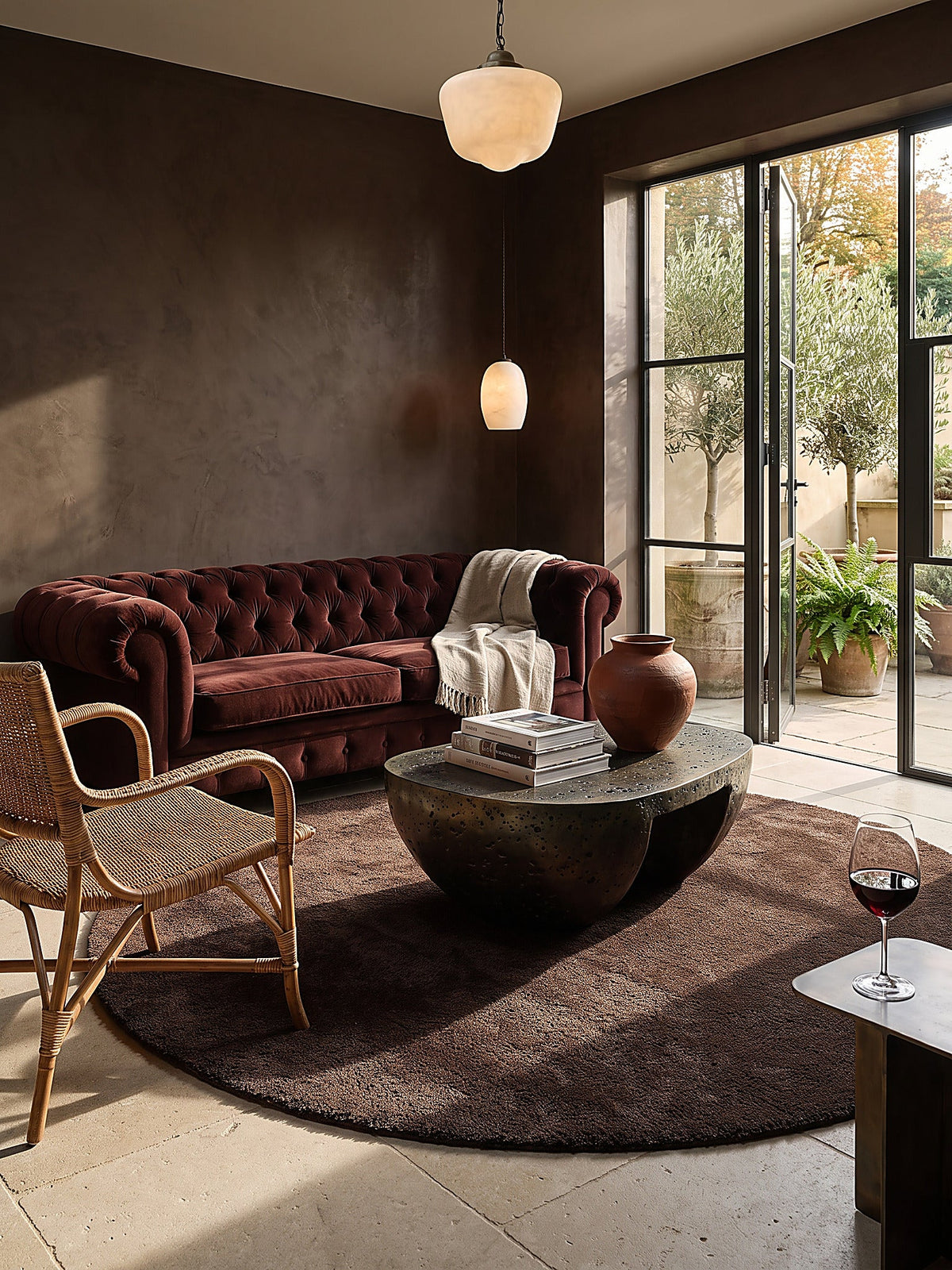 Wohnzimmer mit Chesterfield-Sofa und rundem Hochflor-Teppich in Schokoladenbraun